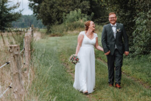 Natürliches Hochzeitspaar in der Natur am Zaun eines Bauernhofes