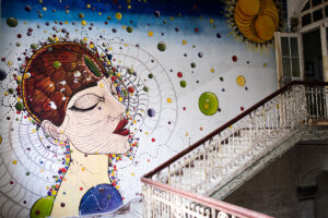 Bunte Wandbemalung einer Frau in einem verlassenen Gebäude