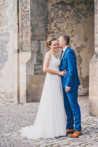 Entspanntes Hochzeitspaar vor einem alten pompösen Gebäude