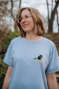 Junge nachdenkliche Frau mit einem Shirt und einem Katzenmotiv